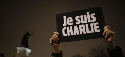 705601-a-man-holds-a-placard-which-reads-i-am-charlie-to-pay-tribute-during-a-gathering-at-the-place-de-la-